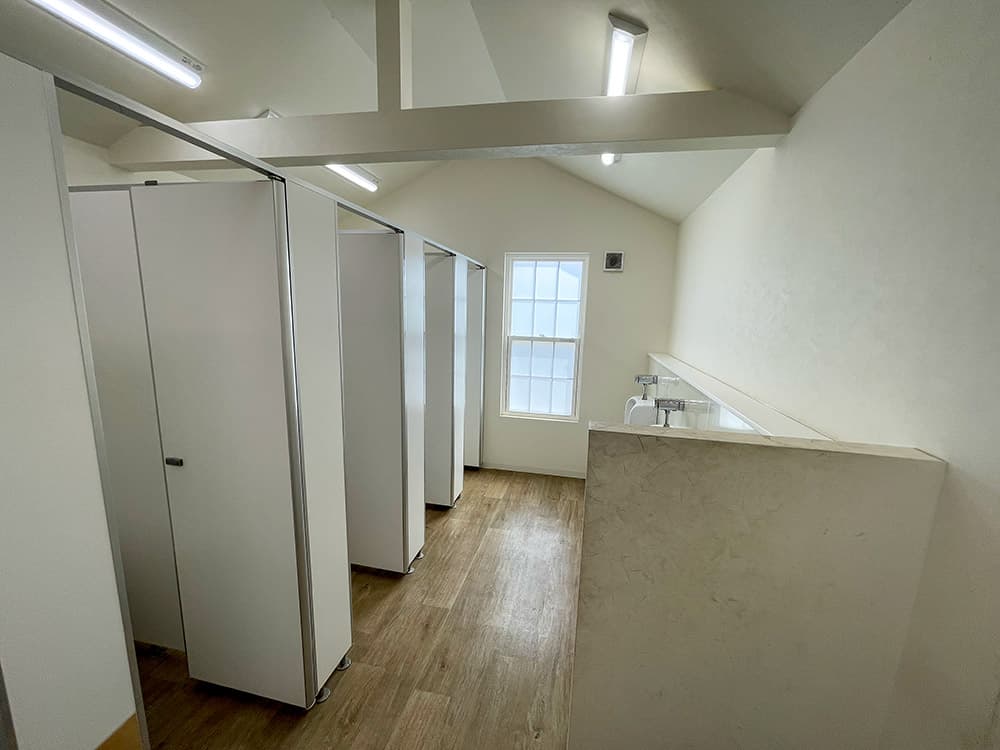 モダンなインテリアデザインのトイレブース、木目調のフローリングと天窓
